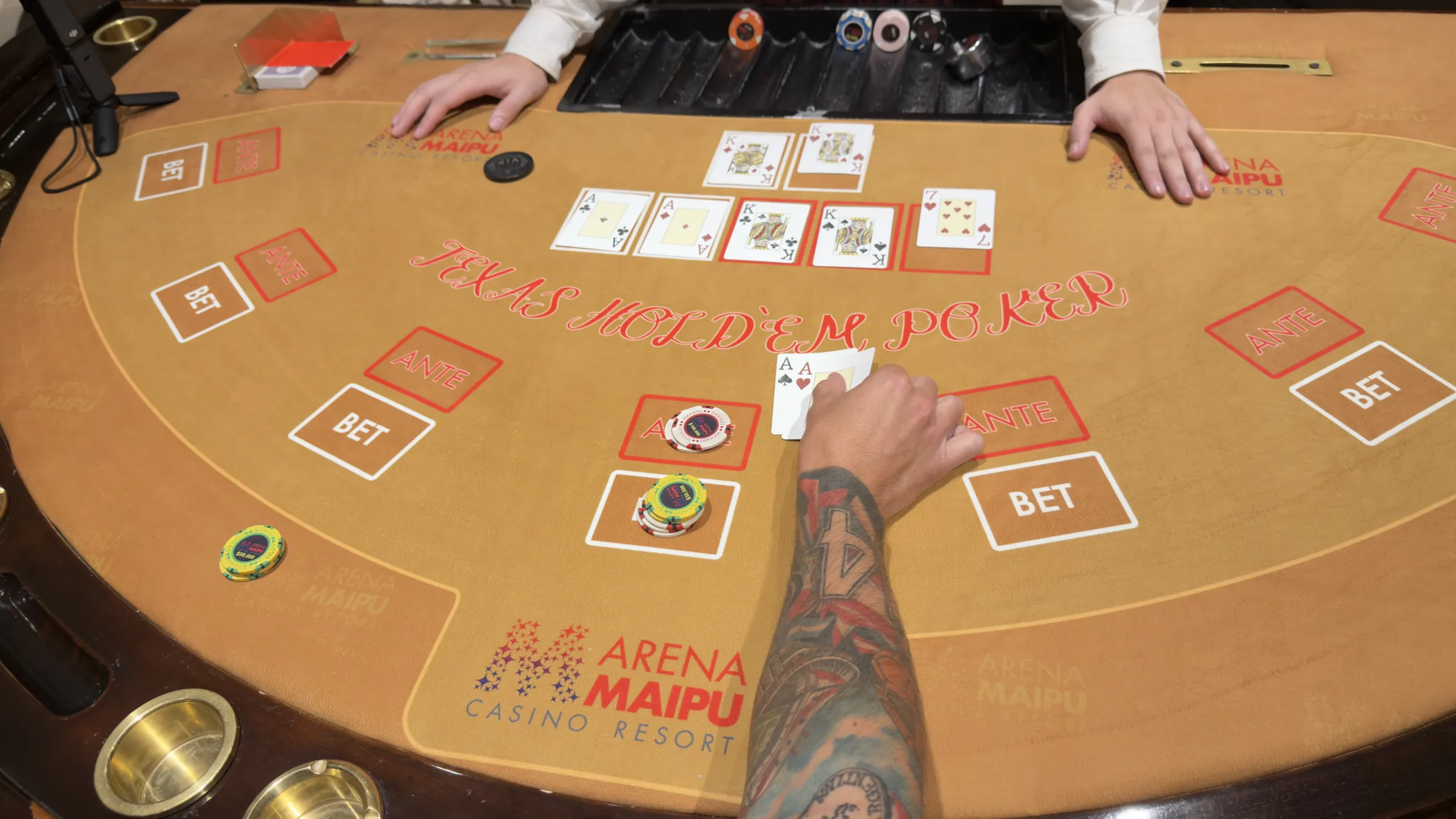 Mesa de Texas Hold'em con cartas y fichas en Casino Arena Maipú